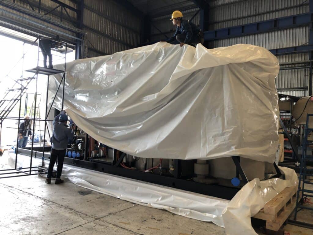 GreenVCI corrosion protection shrink film conforming to irregular shape and size, for heavy equipment transport and storage.